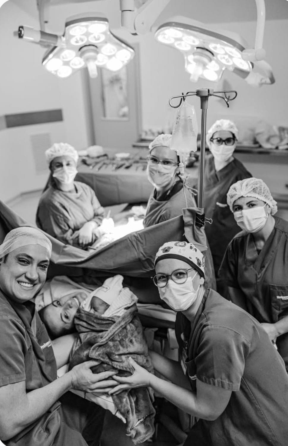 Médicos segurando recém-nascido após parto